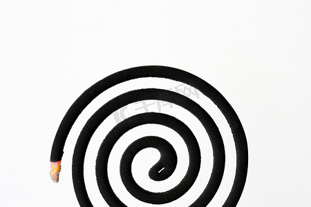 线圈光摄影照片_白色背景上的黑色螺旋驱蚊线圈。