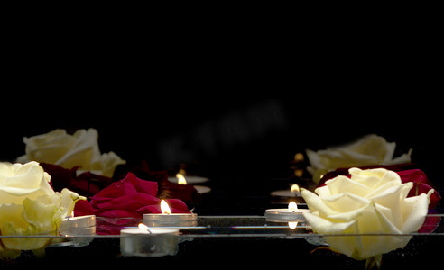 游动摄影照片_蜡烛和玫瑰在水面上游动