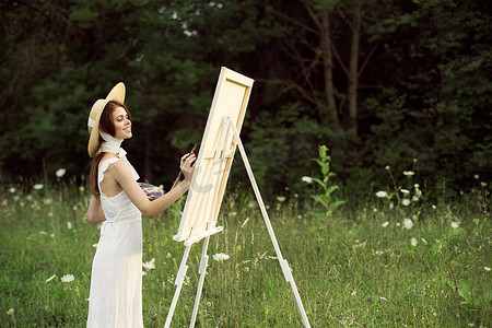 穿着白色连衣裙的漂亮女人在户外绘画艺术创意