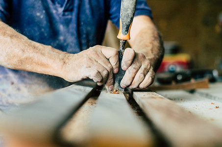专业木匠在工作，他正在使用木工工具雕刻木材，双手特写，木工和工艺概念