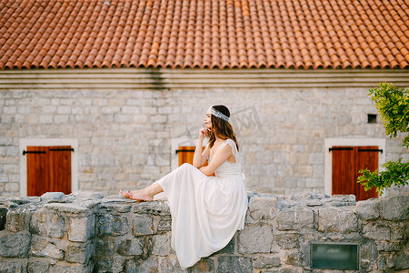 赤脚新娘坐在布德瓦老城的石墙上