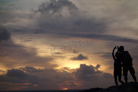 傍晚巴厘岛情侣观赏日落人物形象摄影图