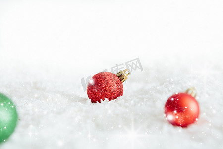雪雪花摄影照片_白色雪中的圣诞球美丽的圣诞小玩意装饰躺在白色蓬松的雪上。