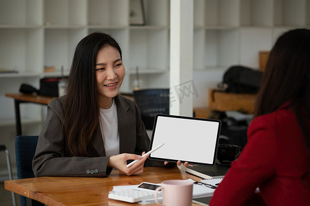 一群年轻的商界人士在会议上集思广益，用空白的白屏平板电脑开始一项新业务。