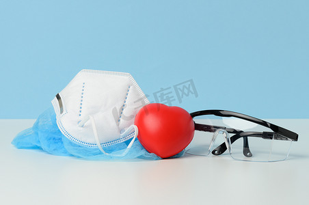 蓝色背景透明塑料防护医用眼镜和白色一次性口罩