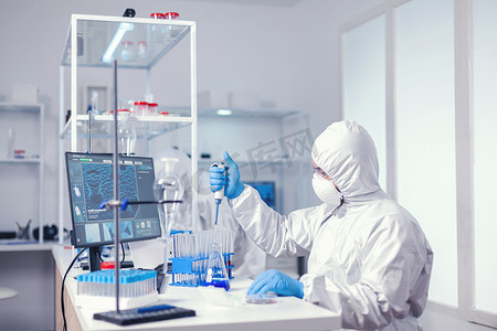 研究人员使用微量移液器测试液体样品