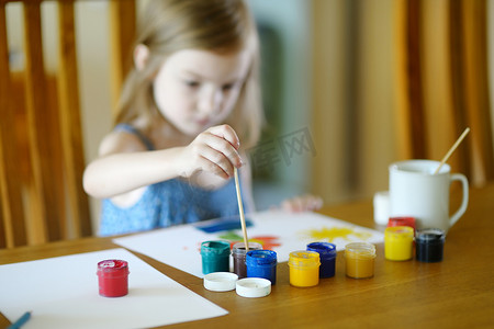 可爱的女孩在幼儿园用颜料画画