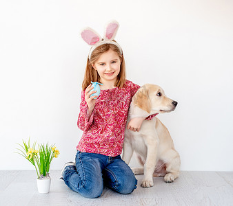 金色兔子摄影照片_拥抱小狗的女孩