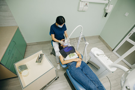 牙医用紫外线灯进行牙齿美白手术。