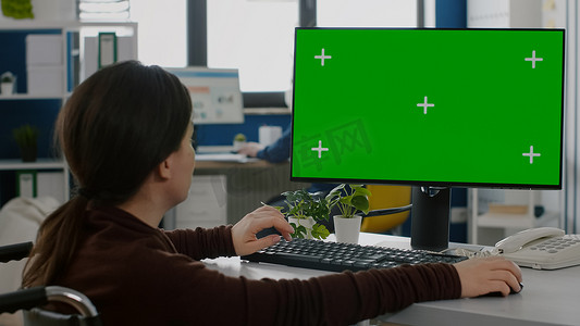在带有绿色模拟屏幕的台式电脑上工作的固定女性