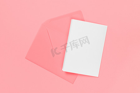 空白白卡与粉红色信封隔离在蓝色背景。