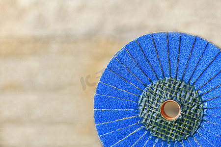 在不锋利的浅米色背景上，在木头和金属上拍打蓝色砂轮。