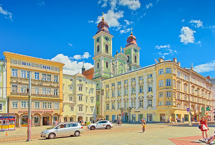摄尔修斯摄影照片_林茨 — 2020年6月，奥地利：林茨主广场的景观，拥有色彩缤纷的历史建筑和旧大教堂（伊格内修斯教堂）