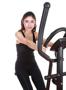 椭圆形不规则图形摄影照片_年轻女子用健身机锻炼