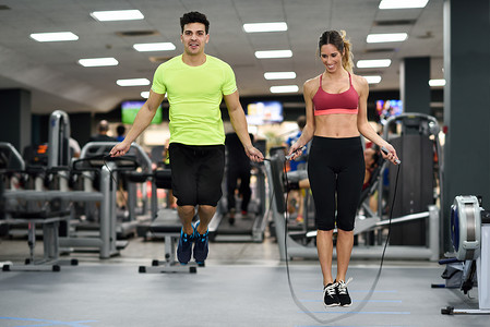 健身房跳绳摄影照片_男女在运动量来找到健身房跳绳锻炼