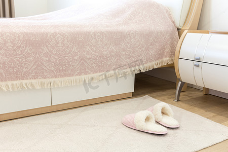 现代风格的卧室，地板上配有粉色舒适的软拖鞋