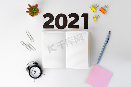 新年快乐创意摄影照片_白桌上的 2022 年数字和文具