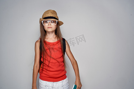 黑色t恤摄影照片_小女孩戴帽子女学生学习教育红色T恤