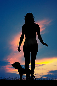 狗跑摄影照片_女人在日落时带着狗跑