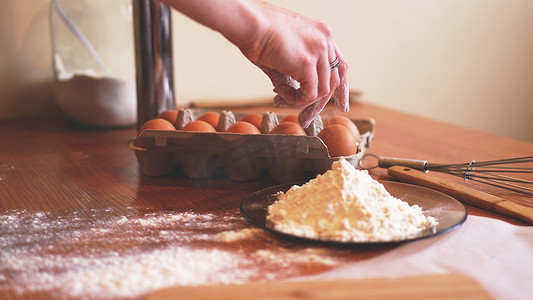 女厨师在做面包时摘鸡蛋做面团的手