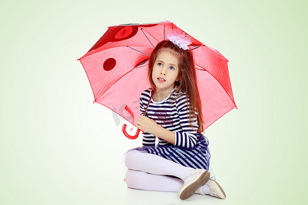 躲在雨伞下的小女孩。