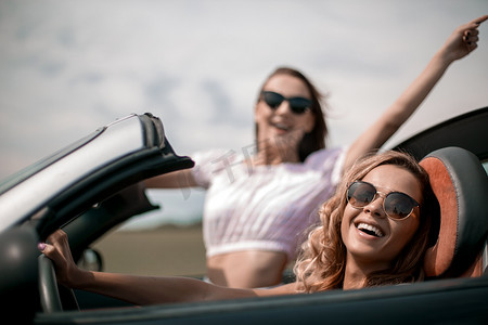 特写。两个快乐的年轻女性在一辆敞篷车里