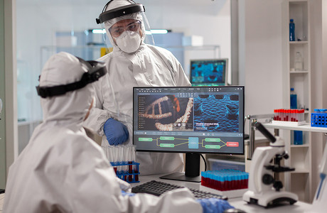 身穿防护服的科学家团队在电脑前讨论治疗方法，观察病毒的发展