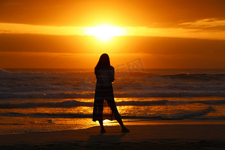 一个单身女人看日出的剪影。