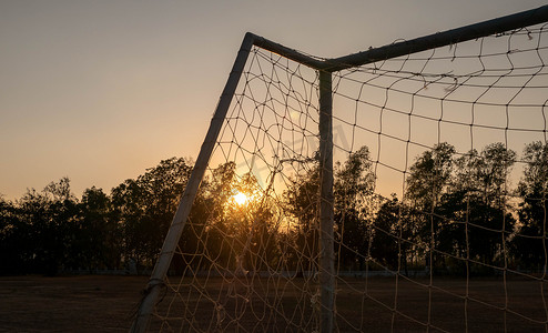 在公共体育场内有日落光背景的足球目标。