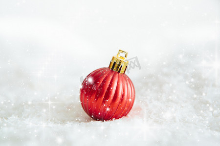 红色圣诞球躺在雪地上 美丽的圣诞小玩意装饰躺在白色蓬松的雪地上。