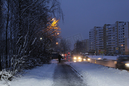 冬季下雪房子摄影照片_冬季城市的夜景，晚上在雪地里，靠近房子和灯笼的树灯巷