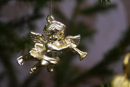 手绘曼陀罗花摄影照片_圣诞贺卡与金色天使在圣诞树上演奏曼陀林。