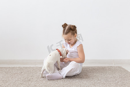 宠物主人、儿童和狗的概念 — 小女孩和可爱的杰克罗素梗小狗坐在地板上玩耍
