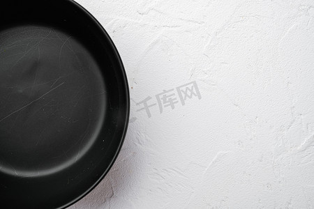 陶器摄影照片_空的黑碗，有文本或食物的复制空间，有文本或食物的复制空间，顶视图平躺，在白色石桌背景上