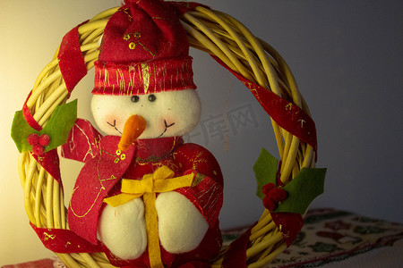 一个用竹子做成的圣诞花环，上面有一个为圣诞节打扮的快乐雪人