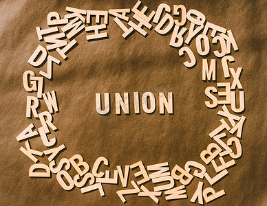联合词在木制立方体字母表字母顶视图在质朴的纸背景。