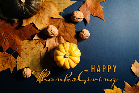 蓝色背景中枫叶、坚果和南瓜的感恩节快乐