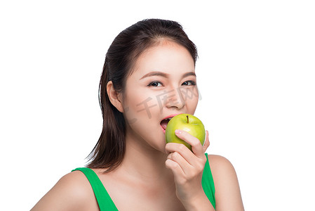 年轻漂亮的亚洲女人在白坝上吃新鲜的青苹果