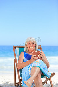 书的海洋摄影照片_在沙滩上看书的高级女人
