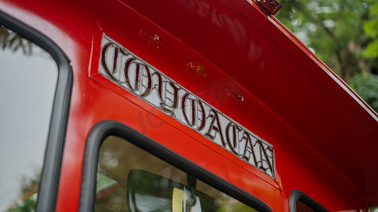 背景树木模糊的红色无轨电车上的科约阿坎标志