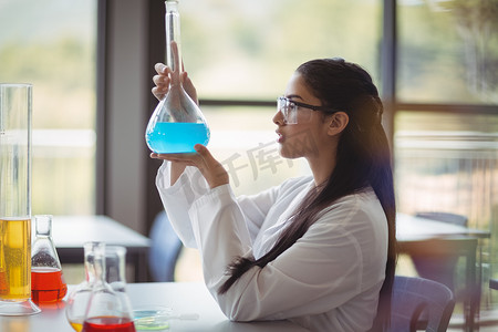 在实验室做化学实验的细心女学生