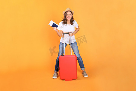 穿着夏季休闲服的年轻旅游女孩，带着红色手提箱、护照、米色背景中突显的门票