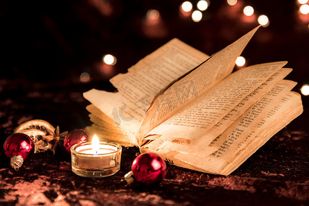 圣诞节用燃烧的蜡烛打开书