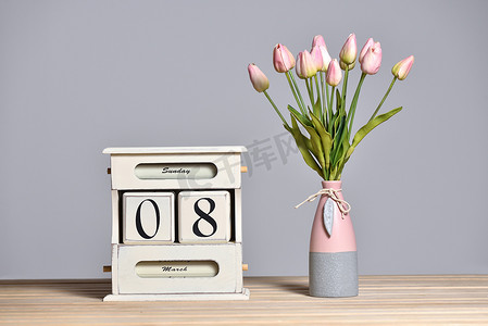 三八日历摄影照片_日期为 3 月 8 日的木制复古日历和花瓶中的郁金香、国际妇女节和灰色墙壁背景上的自由文本空间。