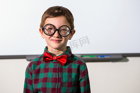 微笑的男孩站在教室白板上