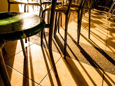 椅子阴影摄影照片_自助餐厅生锈的旧桌椅