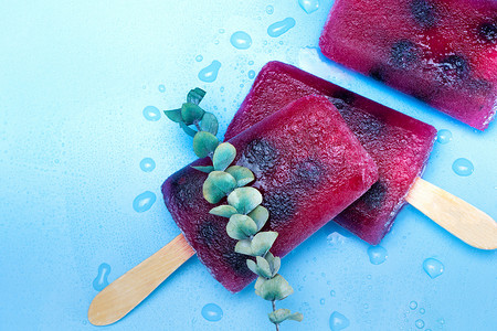 蓝色背景夏季自制覆盆子和蓝莓冰淇淋的顶景、甜点、食品概念现代设计，复制空间色彩缤纷