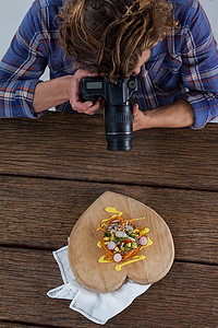 摄影师使用数码相机点击食物图片