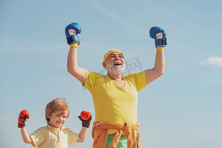 拳击手祖父和孩子，蓝天背景上戴着蓝色拳击手套 — 孤立。