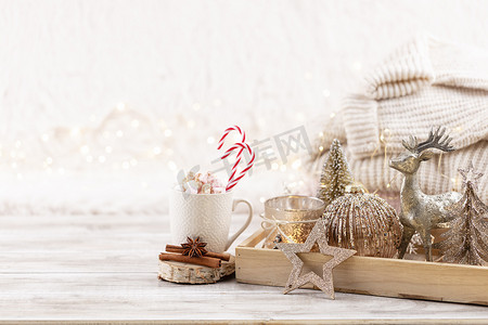 杯子里有热饮，桌上有棉花糖，上面有圣诞装饰。